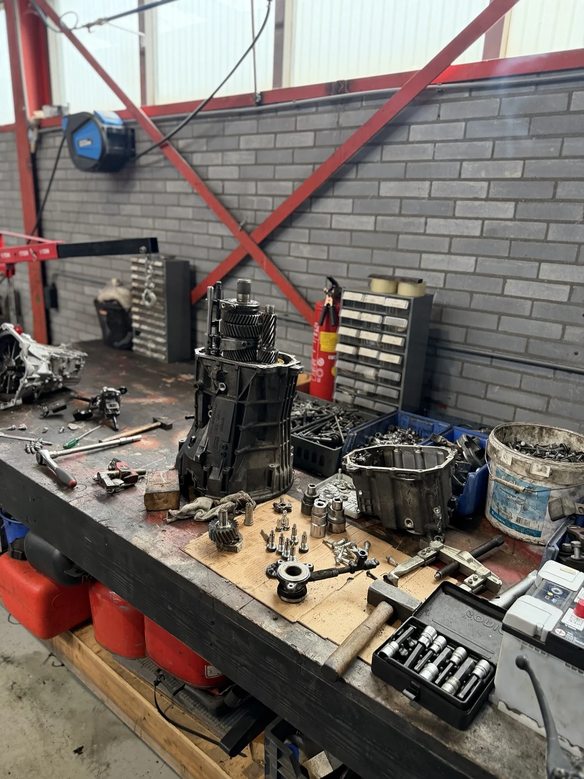 Onderdelen en gereedschap op de werkbank bij De Roo